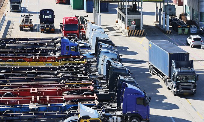 화물연대 파업 12일째인 5일 경기도 의왕시 내륙컨테이너기지(ICD)에서 컨테이너를 싣고 있는 화물차가 파업으로 멈춰 선 화물차 사이를 오가고 있다. 연합뉴스