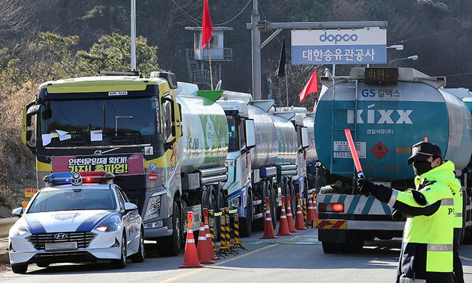 속속 운송 복귀 화물연대 총파업이 12일째 계속되고 있는 5일 경기 성남시 분당구 대한송유관공사 서울지사 앞 도로에 파업에 참여한 유조차가 멈춰서 있는 반면 파업에 불참한 유조차가 경찰의 안내를 받으며 이동하고 있다. 성남=남정탁 기자