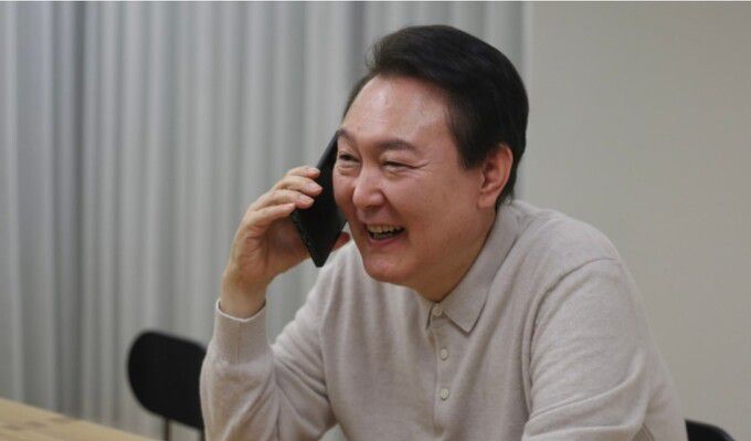 윤석열 대통령이 3일 카타르 월드컵 16강 쾌거를 거둔 축구대표팀 파울루 벤투 감독, 주장 손흥민 선수와 전화 통화를 하며 환하게 읏음짓고 있다. 대통령실 제공