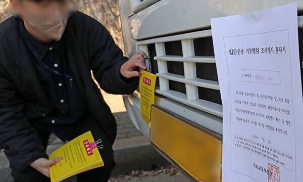 정부가 8일 철강·석유화학 업종 운송거부자에 대한 업무개시명령을 발동한 가운데 국토교통부와 포항시 관계자가 이날 오후 포항철강산업단지 갓길에 세워진 민주노총 화물연대 소속 조합원의 화물차에 '집단운송 거부행위 조사개시 통지서'와 '단속 예고장'을 붙이고 있다. 연합뉴스