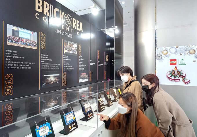19일 서울 코엑스 1층 로비에서 개막한 대한민국 최대 레고 창작전시회 ‘브릭코리아 컨벤션 10주년 기념전’에 방문한 관람객들이 전시 주요 연혁을 살펴보고 있다.