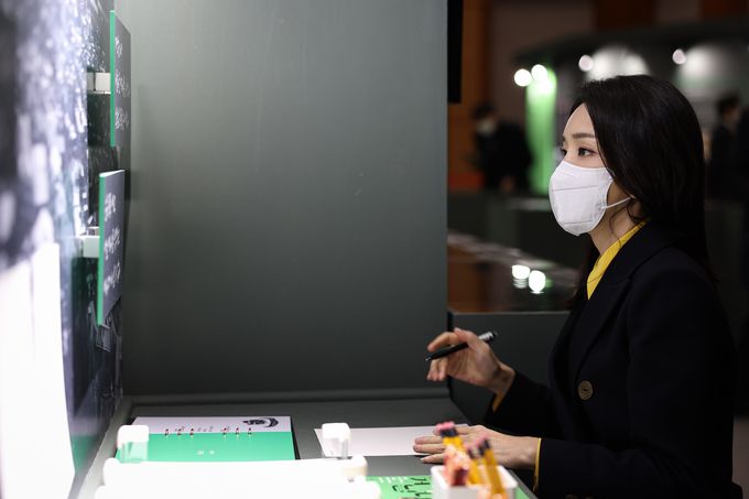 윤석열 대통령 부인 김건희 여사가 9일 서울 종로구 청와대에서 문학 특별전시 ‘이상, 염상섭, 현진건, 윤동주 청와대를 거닐다’를 관람한 뒤 윤동주 시인의 작품을 직접 자필로 써보고 있다. 대통령실 제공