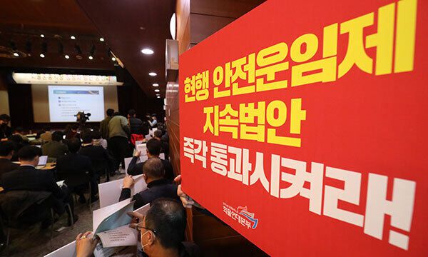 18일 서울 중구 포스트타워에서 국토교통부 주최로 열린 화물운송시장 정상화 방안 공청회에 화물연대 노조원들이 손 피켓을 들고 참석하고 있다. 뉴스1