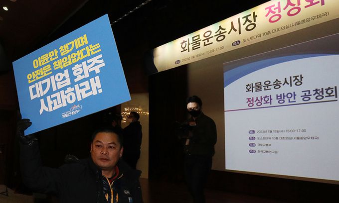18일 서울 중구 포스트타워에서 국토교통부 주최로 열린 화물운송시장 정상화 방안 공청회에 화물연대 노조원들이 손 피켓을 들고 참석하고 있다. 뉴스1