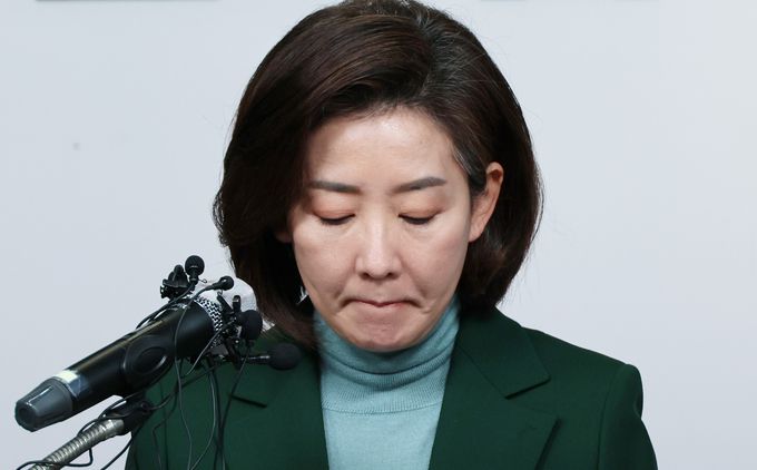 국민의힘 나경원 전 의원이 25일 오전 서울 여의도 국민의힘 당사에서 기자회견을 열고 전당대회 불출마 선언문을 읽으며 입술을 깨물고 있다. 연합뉴스