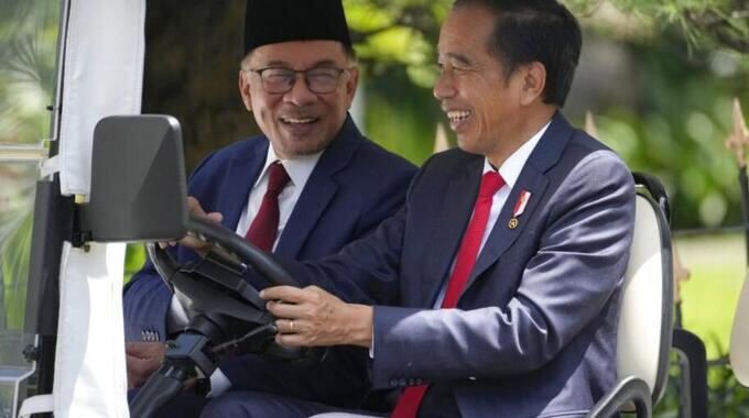 안와르 이브라힘 말레이시아 총리(왼쪽)가 지난 9일 인도네시아 대통령궁에서 이뤄진 정상회담에 앞서 조코 위도도 인도네시아 대통령이 운전하는 전동카드에서 대화를 하며 웃고 있다. 보고르=로이터연합뉴스