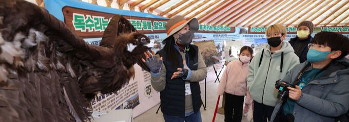 체험객들이 해설사로부터 독수리 생태이야기를 듣고 있다.