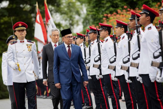 안와르 이브라힘 말레이시아 총리(앞쪽)와 리센룽 싱가포르 총리(뒤쪽)가 지난 1월 30일 싱가포르 대통령궁에서 열린 안와르 총리의 방문 환영 행사에서 의장대를 사열하고 있다. 싱가포르=EPA·연합뉴스