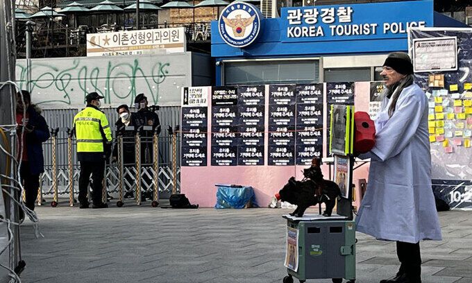 이태원 참사 희생자 분향소에서 조문객 A씨가 직접 준비한 의상과 소품을 활용해 대통령을 비판하는 퍼포먼스를 하고 있다. 왼쪽에서는 김상진 신자유연대 대표가 A씨의 모습을 생중계하고 있다. 윤준호 기자