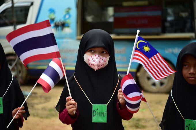 말레이시아에 인접한 태국 남부의 나라티왓 지역의 한 모스크에서 무슬림 아동이 지난 5일 관광객의 방문을 환영하면서 양국의 국기를 흔들고 있다. 나라티왓=AFP연합뉴스