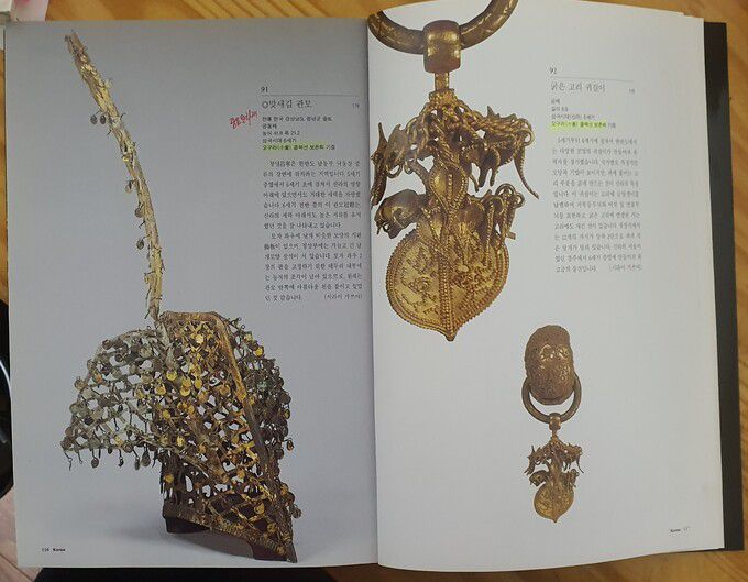 일본 도쿄국립박물관의 ‘동양미술 100선’(한글판)에 실린 금동관모(왼쪽)와 귀걸이. 두 점 모두 오구라컬렉션 보존회 기증으로 표시돼 있다.