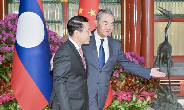 왕이 중국 공산당 정치국 위원(오른쪽)이 베이징 공산당 외교위 사무에서 살름싸이 꼼마싯 라오스 부총리 겸 외교장관에게 안내를 하고 있다. 베이징=신화통신·연합뉴스