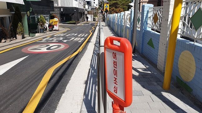 지난 3월13일 서울 강남구 언북초등학교 후문 인근 도로에 어린이보호구역 안내와 일방통행 등 노면 표시가 새겨져 있다. 학교 담장을 따라서는 인도와 보행자 보호를 위한 울타리가 설치됐다. 김동환 기자