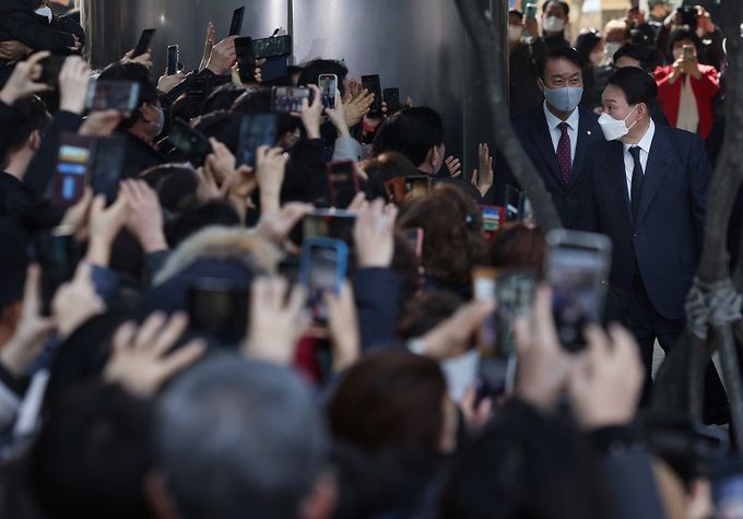 지난해 3월10일 당시 윤석열 대통령 당선인이 서울 서초동 자택을 나서면서 지지자들과 동네 주민들에게 인사를 하고 있다. 연합뉴스