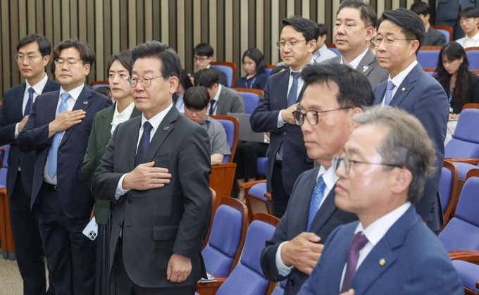 더불어민주당 이재명 대표(왼쪽 네 번째)가 25일 서울 여의도 국회에서 열린 의원총회에서 소속 의원들과 함께 국기에 경례하고 있다. 최상수 기자