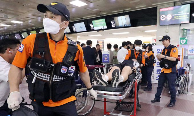 26일 대구공항에서 119구조대가 전국소년체육대회에 참가하기위해 아시아나항공 여객기에 탑승한 제주특별자치도 선수단 가운데 호흡고통을 호소한 선수들을 들것을 이용해 구급차로 옮기고 있다. 대구=뉴스1