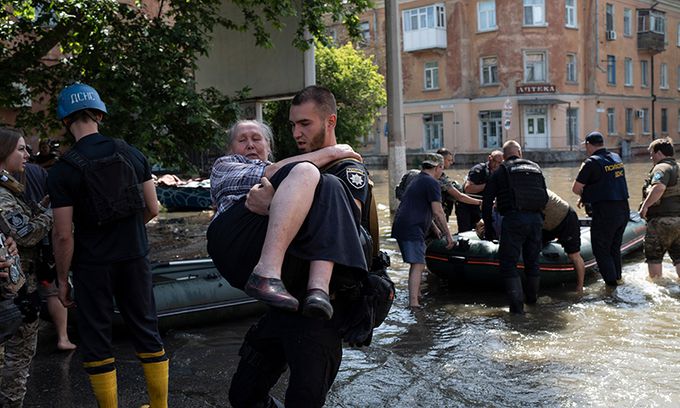 24개 마을 침수… 1만7000여명 대피 우크라이나 헤르손주의 노바 카호우카 댐이 원인불명의 폭발로 붕괴된 가운데 홍수가 발생한 댐 인근 마을에서 6일(현지시간) 한 노인이 구조대원에 안겨 구출되고 있다. 우크라이나 내무부는 이날 댐 붕괴로 주변 24개 마을이 물에 잠겨 1만7000여명이 대피했다고 밝혔다. 헤르손=AP연합뉴스