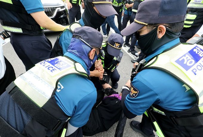 지난 7일 서울 구로구 서울남부구치소에서 보석으로 풀려난 박희영 서울 용산구청장의 차량 앞을 10·29 이태원 참사 유가족협의회가 가로막자 경찰이 저지하고 있다. 뉴스1