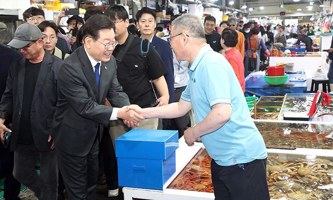 이재명 더불어민주당 대표가 22일 오후 강원 강릉시 주문진 좌판풍물시장에서 상인들과 악수하고 있다. 강릉=뉴스1