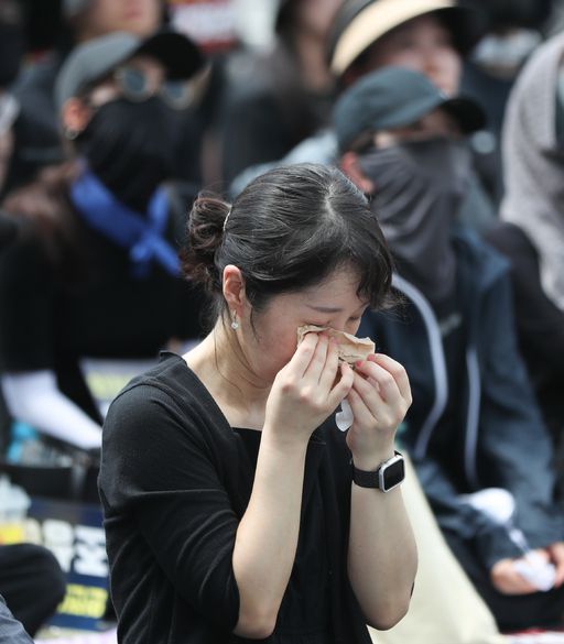 고인을 추모하는 영상을 보던 집회 참가자가 눈물을 닦고 있다. 뉴스1