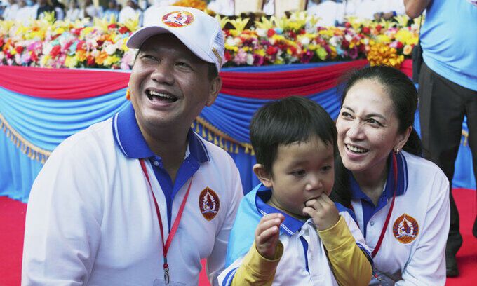 캄보디아 차기 총리로 지명될 훈마넷이(왼쪽)이 7월 1일 프놈펜에서 펼쳐진 선거유세에서 아내(오른쪽)와 함께 지지자의 아이를 가운데에 두고 웃고 있다.  프놈펜=AP연합뉴스
