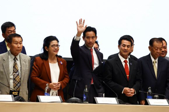 태국의 피타 림짜른랏 전진당 대표가 7월 18일 연립정부 참여를 선언한 각당 대표들과 자리를 함께 한 뒤 손을 흔들고 있다. 방콕=로이터·연합뉴스
