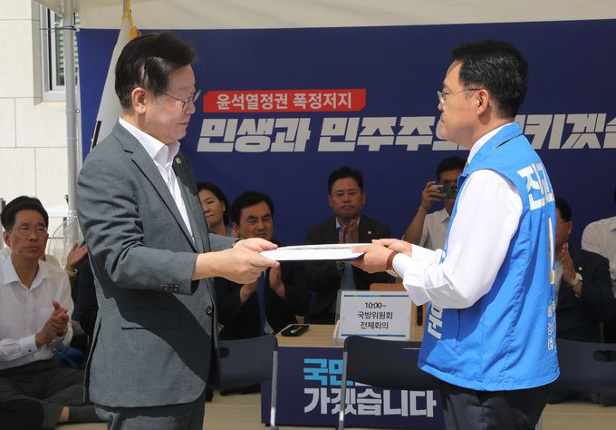 이재명 더불어민주당 대표가 6일 오전 서울 여의도 국회 본청앞 단식투쟁천막에서 열린 더불어민주당 서울 강서구청장 보궐선거 후보자 공천장 수여식에서 진교훈 후보에게 후보자 추천서를 수여하고 있다.   뉴스1