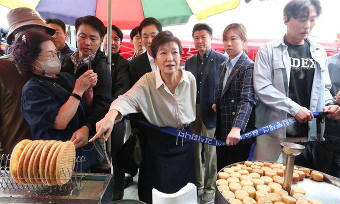 박근혜 전 대통령이 추석을 앞둔 지난 25일 대구 달성군 현풍시장을 찾아 먹거리를 구매하고 있다. 뉴시스