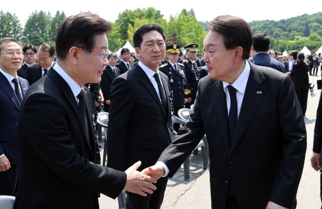 윤석열 대통령(오른쪽)이 지난 6월6일 서울 동작구 국립서울현충원에서 열린 제68회 현충일 추념식을 마친 뒤 이재명 더불어민주당 대표와 악수하고 있다. 뉴시스