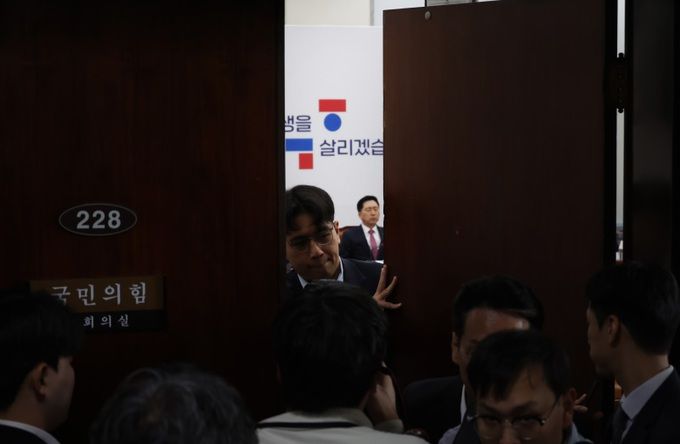 12일 오전 서울 여의도 국회 당 최고위원회의를 앞두고 어두운 표정을 짓는 김기현 국민의힘 대표를 뒤로 한 채 관계자가 회의실 출입문을 닫고 있다. 연합뉴스