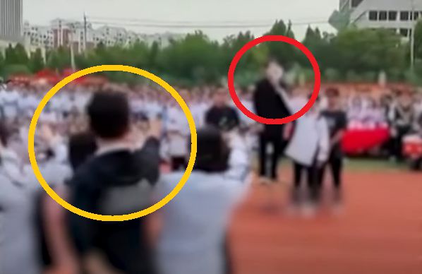 지난달 28일 중국 산둥성의 한 중학교 체육대회에서 일본의 아베 전 총리(빨간 동그라미) 역할을 맡은 학생에게 총격범(노란 동그라미) 역할 학생에게 총을 쏘는 퍼포먼스를 하고 있다.