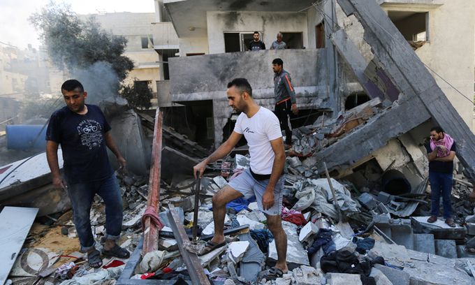 지난 18일(현지시간) 팔레스타인 사람들이 가자 지구의 가자시티에서 이스라엘의 공습으로 무너진 건물 잔해를 밟으면서 생존자들을 찾고 있다. AP뉴시스