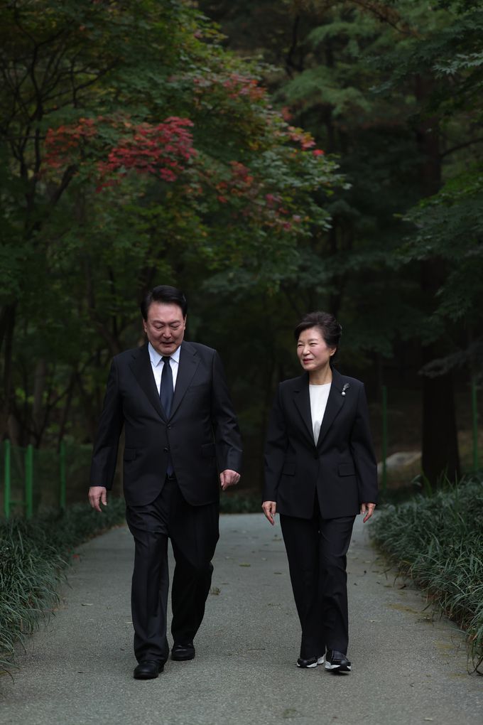 윤석열 대통령이 26일 서울 동작구 국립서울현충원에서 열린 박정희 전 대통령 서거 제44주기 추도식에서 박근혜 전 대통령과 함께 묘소를 참배한 후 이동하며 대화를 나누고 있다. 대통령실 제공