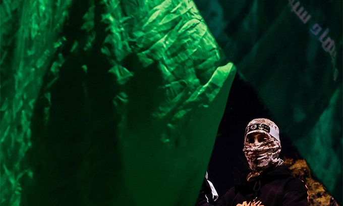 지난 1일(현지시간) 이스라엘 요르단강 서안 라말라에서 팔레스타인 수감자들이 석방된 뒤 하마스 대원으로 보이는 남성이 커다란 하마스기 아래 서 있는 모습이 포착됐다. 로이터연합뉴스