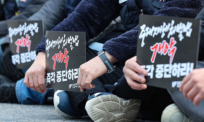 5일 서울 여의도 국회 앞에서 열린 중대재해처벌법 개악 중단 촉구 민주노총 결의대회에서 민주노총 조합원들이 손피켓을 들고 있다. 뉴시스