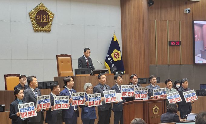 충남학생인권조례 폐지안 처리가 예정된 15일 충남도의회 제348회 정례회 제4차 본회의에 앞서 더불어민주당 도의원들이 '역사 앞에 부끄러울 학생인권조례 폐지 반대'라는 손팻말을 들고 서 있다. 연합뉴스