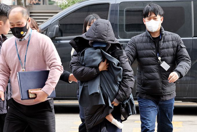 배우 고(故) 이선균을 협박해 수천만원을 받아낸 20대 여성 A씨(앞줄 오른쪽)가 지난달 28일 오후 미추홀구 소재 인천지법에서 열린 구속 전 피의자 심문(영장 실질심사)에 아이를 안은 채 출석하고 있다. 인천=뉴스1