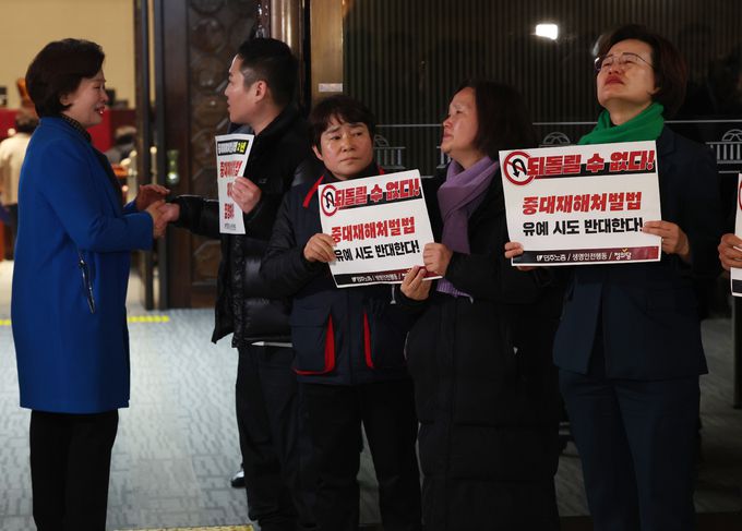 이수진 더불어민주당 의원이 지난 1일 서울 여의도 국회에서 비공개로 열린 더불어민주당 의원총회 회의장 앞에서 '중대재해처벌법 개악 협상 중단 촉구' 피켓팅을 정의당과 한국노총, 민주노총 회원들을 격려하고 있다. 뉴스1
