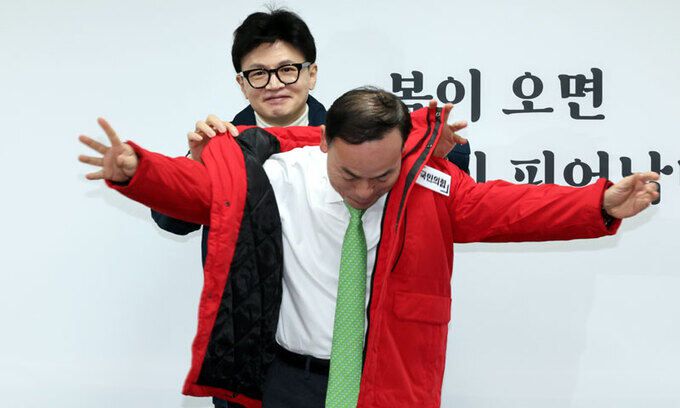 국민의힘 한동훈 비상대책위원장(뒤)이 29일 서울 영등포구 중앙당사에서 열린 영입인재 환영식에서 김윤식 전 시흥시장에게 당 점퍼를 입히고 있다. 김 전 시장은 민주당에서 경기 시흥을 공천을 신청했다가 부적격 판정을 받고 당적을 옮겼다. 서상배 선임기자