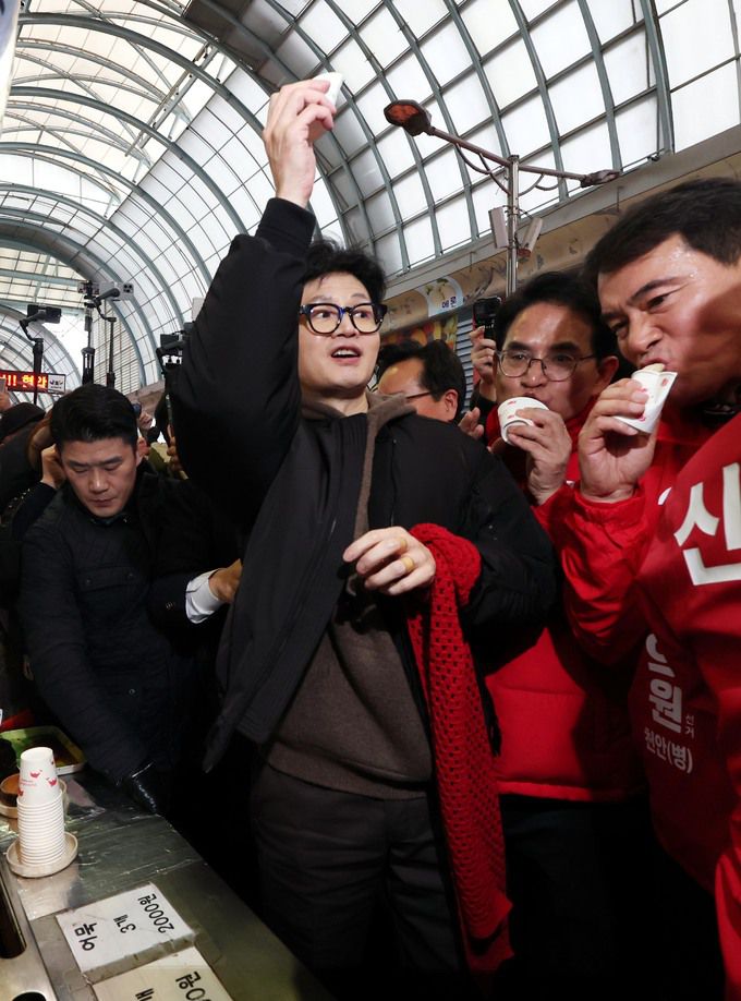 한동훈 국민의힘 비상대책위원장이 4일 오후 충남 천안시 동남구 천안중앙시장에서 호떡을 먹으며 시민들에게 인사하고 있다. 사진 = 뉴시스