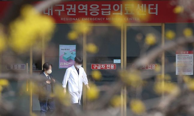 3일 대구 한 대학병원 응급실 앞에 개화한 산수유꽃 앞으로 의료진이 이동하고 있는 모습. 대구=연합뉴스