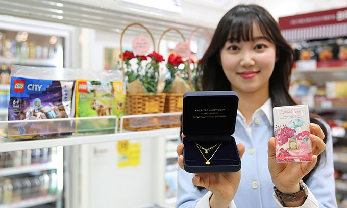 GS25 모델이 어버이날을 기념해 출시한 카네이션 목걸이와 카네이션 골드바 상품을 선보이고 있다. GS25 제공