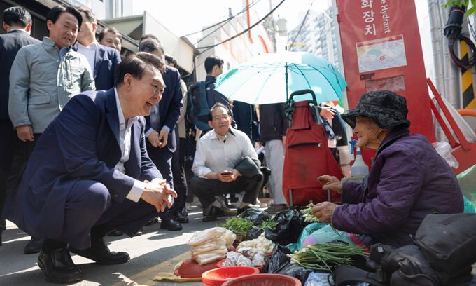 윤석열 대통령이 10일 서울 서대문구 영천시장을 찾아 노점에서 채소를 판매하는 어르신과 대화하고 있다. 대통령실 제공