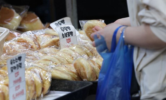 21일 서울 동대문구 경동시장에서 한 시민이 빵을 고르고 있는 모습. 연합뉴스