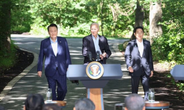 2023년 8월 18일(현지시간) 윤석열 대통령, 조 바이든 미국 대통령, 기시다 후미오 일본 총리가 워싱턴DC 인근 미국 대통령 별장인 캠프 데이비드에서 한미일 정상 공동기자회견을 위해 오솔길을 함께 걸어 오고 있다. 연합뉴스