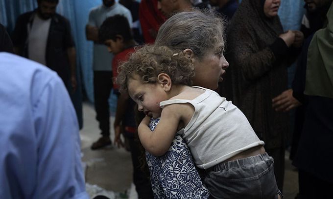 이스라엘 가자지구 중부 데이르 알발라의 알아크사 병원에서 팔레스타인 소녀가 이스라엘의 부레이 난민촌 주거용 건물 폭격으로 다친 동생을 안고 치료를 기다리고 있다. AP뉴시스