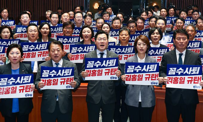 더불어민주당 박찬대 대표 직무대행 겸 원내대표를 비롯한 의원들이 2일 서울 여의도 국회에서 열린 의원총회에서 김홍일 방송통신위원장의 사퇴를 규탄하는 손피켓을 들고 구호를 외치고 있다. 뉴스1