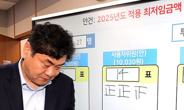 이인재 최저임금위원장이 12일 새벽 정부세종청사에서 열린 제11차 전원회의가 끝난 뒤 기자들의 질문에 답하고 퇴장하고 있다. 이날 최저임금위는 노사 양측 최종안의 표결을 거쳐 내년 최저임금을 시간당 1만30원으로 결정했다. 연합뉴스