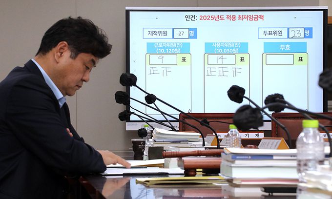 최저임금위원회는 12일 새벽 정부세종청사에서 열린 제11차 전원회의에서 투표를 거쳐 내년 최저임금을 시간당 1만30원으로 결정했다. 사진은 회의가 끝난 뒤 이인재 최저임금위원장이 자리에서 생각에 잠겨 있는 모습. 연합뉴스