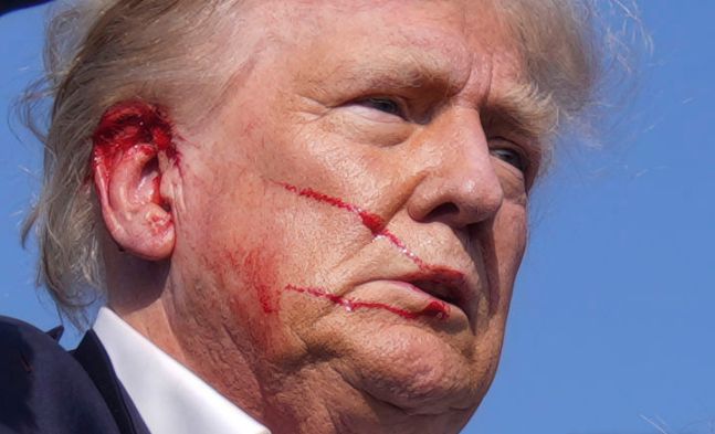 도널드 트럼프 전 미 대통령이 13일(현지시각) 펜실베이니아주 버틀러에서 집회 도중 암살 시도로 오른쪽 귀에 총을 맞아 피를 흘리며 대피하고 있다. 버틀러(미 펜실베이니아주)=AP/뉴시스